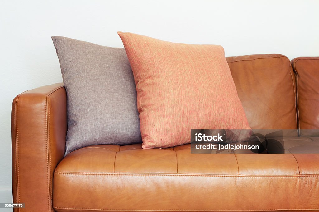 Close up of tan leather sofa with linen cushions Close up of tan leather sofa with two linen cushions Beige Stock Photo