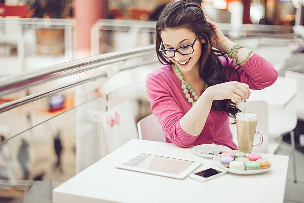 Young woman reading tablet and drinking latte in a cafe