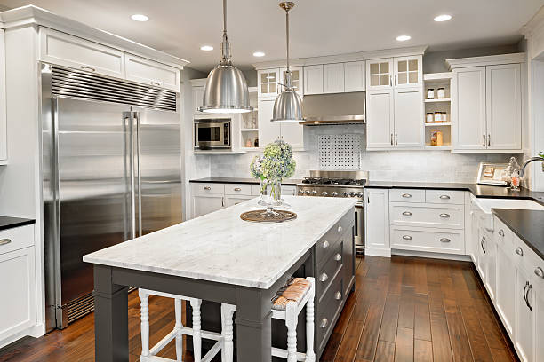 beautiful kitchen in luxury home with island and stainless steel - huishoudelijk apparaat fotos stockfoto's en -beelden