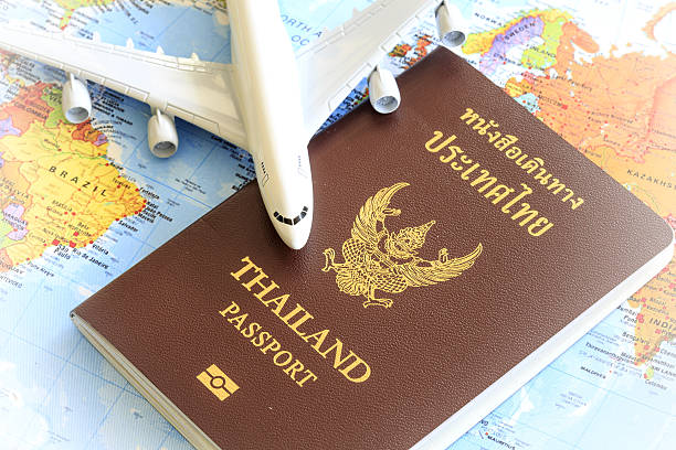 istock Toy plane resting on a thailand passport and world map 535716227