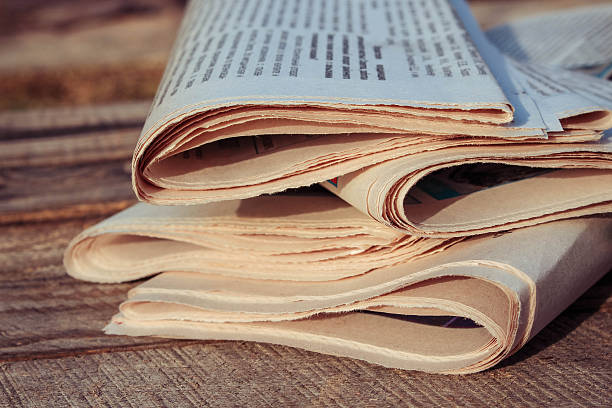 istock Newspapers on old wood background. Toned image. 535716453