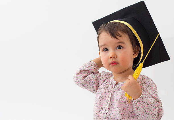 Little girl with graduation hat isolated on white background stock photo