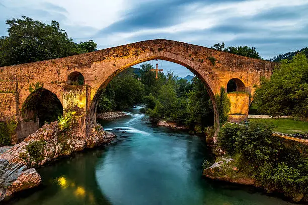 Old Roman stone bridge in Cangas de Onis (Asturias) at sunset, Spain 