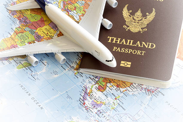 istock Toy plane resting on a thailand passport and world map 535722499
