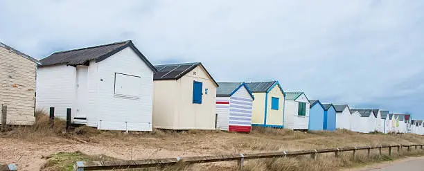 A row of beach huts on a dull winters day by the seaside.