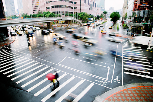 Traffic crossing a busy road junction, blurred by motion, close to Taipei 101. Taipei, Taiwan. 