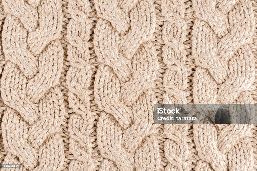 Knitted fabric texture Knitted fabric texture close-up, beige color,  aran Sweater. 2015 Stock Photo
