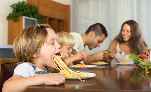 istock Family of four eating spaghetti 535725841