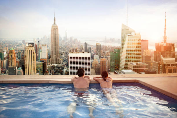 couple de détente sur le toit de l'hôtel - manhattan skyline new york state skyscraper photos et images de collection