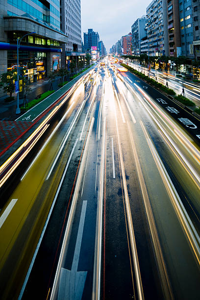 Traffic travelling along a busy highway, blurred by motion, at night. Taipei, Taiwan. 
