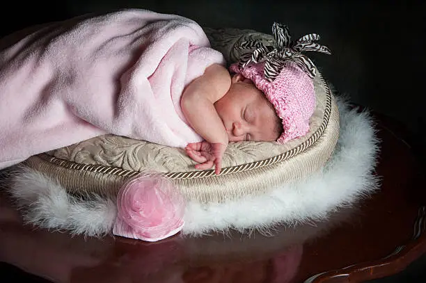 Photo of Newborn Baby girl sleeping wrapped in pink