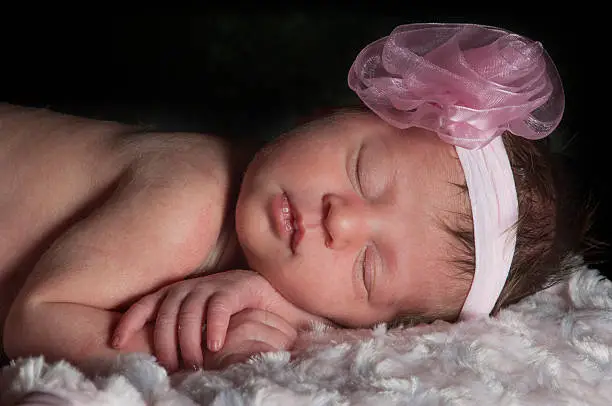 Photo of Newborn Baby girl sleeping wrapped in pink