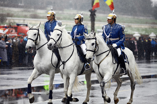 Bucharest, Romania - December 1, 2014: Mounted soldiers ride horses during celebrations for Romania's national day in Bucharest, Romania. 