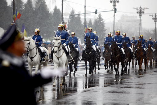 Bucharest, Romania - December 1, 2014: Mounted soldiers ride horses during celebrations for Romania's national day in Bucharest, Romania. 