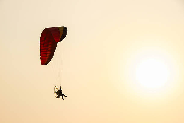 paramoter and a soft sun Silhouette paramotor with mostly clear and a soft sun para ascending stock pictures, royalty-free photos & images