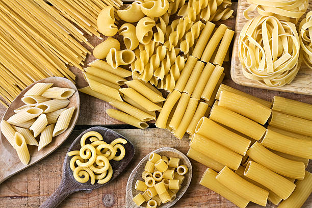 pasta con sfondo in legno - pasta whole wheat spaghetti raw foto e immagini stock