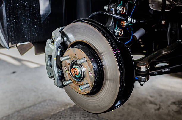 istock Front disc brake on car in process of tire replacement. 535771481