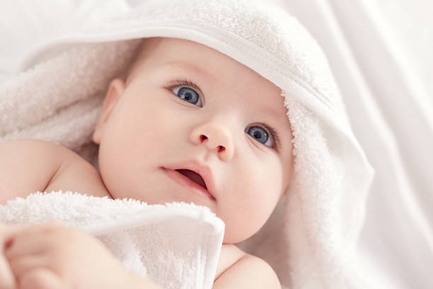 istock Baby with blus eyes under the white towel 535771527