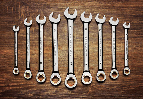 Set of wrenches on wooden background, close up