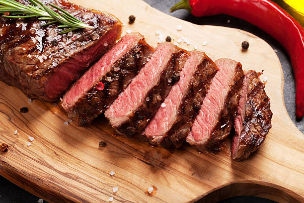 Grilled striploin steak Grilled striploin sliced steak on cutting board over stone table roast dinner photos stock pictures, royalty-free photos & images