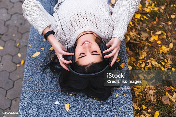 Female Student Girl Outside In Park Listening To Music On Stock Photo - Download Image Now