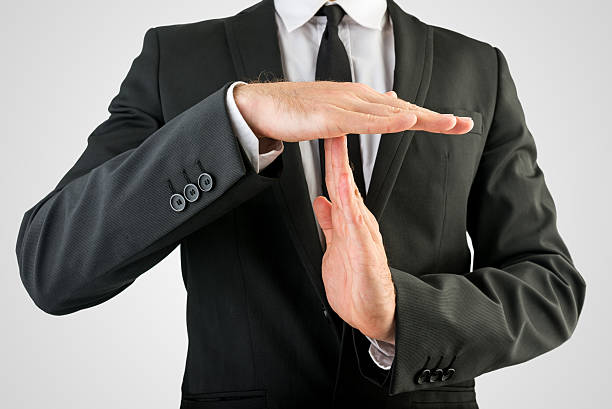 Businessman Showing Time Out Hand Sign Close up Businessman in Black Suit Showing Time Out Sign, Isolated on Gray Background. time out signal stock pictures, royalty-free photos & images