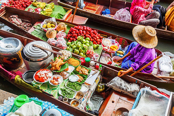 frau im markt damnoen saduak in thailand - thai culture fotos stock-fotos und bilder