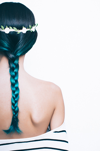 Young girl with a green dyed hair wearing a floral wreath