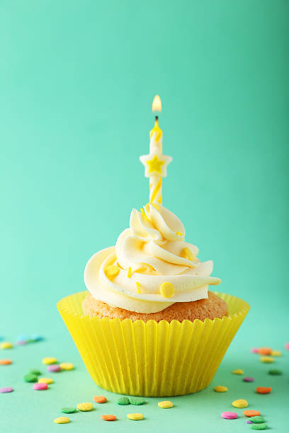 istock Tasty cupcake with candle on green background 535810735