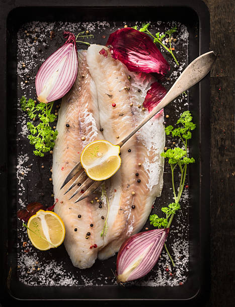 istock raw fish with herb, spices and fork on  backing tray 535813177