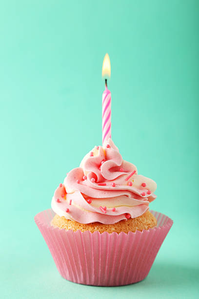 istock Tasty cupcake with candle on green background 535814591