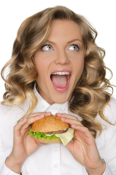 istock young woman with hamburger looking away 535843865