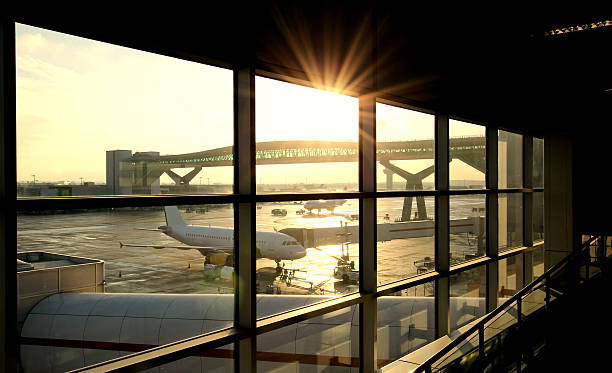 Airport Departure Lounge Airport departure lounge with passenger plane being loaded. passenger boarding bridge stock pictures, royalty-free photos & images