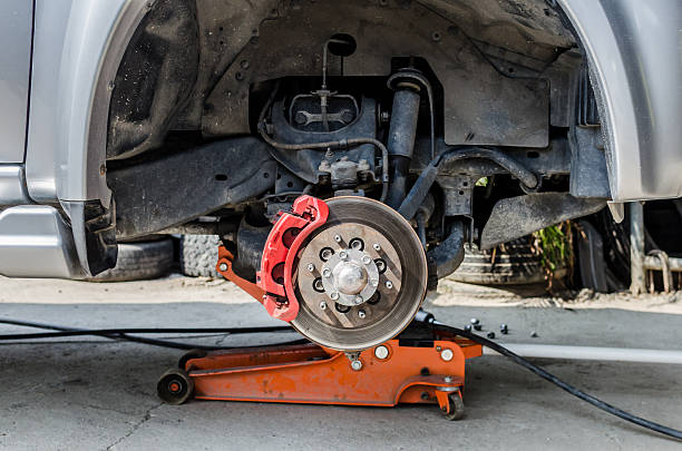 istock Front disc brake on car in process of tire replacement. 535844781