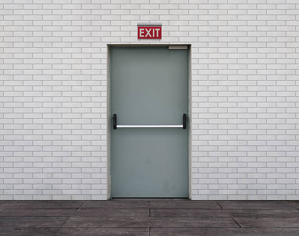 Emergency Exit Door Emergency exit door with white brick wall and hardwood floor. exit sign photos stock pictures, royalty-free photos & images