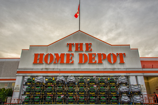 Ottawa, Canada - April 15, 2013: John Deer lawn mowers stacked three high in front of the entrance to the renovation store Home Depot on a cloudy day 