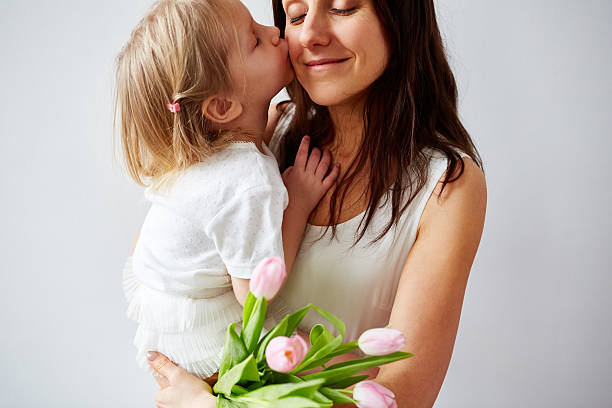 Little daughter kissing her mom on Mother's Day