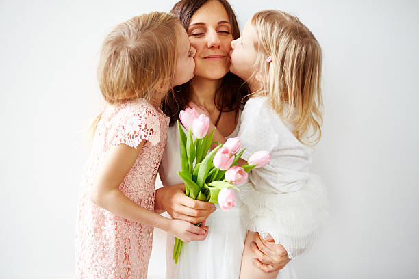 meilleur cadeau jamais - mothers day mother kissing child photos et images de collection