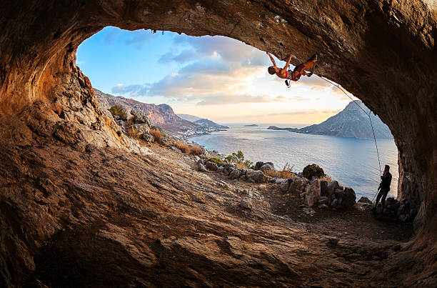 若い女性リードを登るケイヴ - climbing men sea cliff ストックフォトと画像