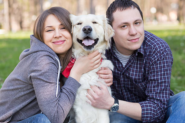 istock Smiling young man and woman hugging a dog 535851757