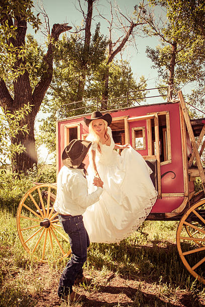 istock Cowboy Groom Lifting His Bride From An Old Stagecoach 535851837