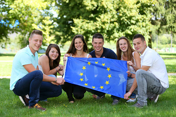 Group of teenagers and Flag Group of teenagers with the European flag ecole stock pictures, royalty-free photos & images