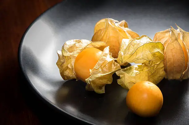 Physalis fruit or capegooseberry on black plate.