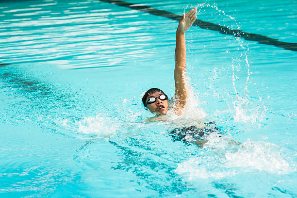 jeune homme à nager dans dos crawlé dans une piscine. - dos crawlé photos et images de collection