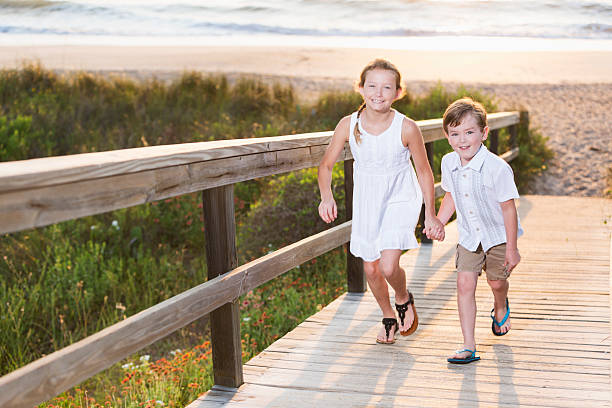 crianças correndo na praia boardwalk - beach family boardwalk footpath - fotografias e filmes do acervo