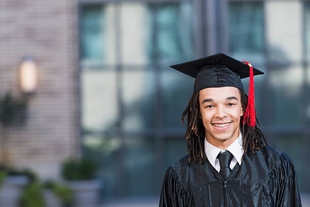 istock Young man in graduation cap and gown 535869565