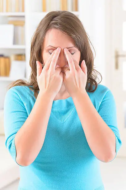 Woman doing EFT on the eye brow point. Emotional Freedom Techniques, tapping, a form of counseling intervention that draws on various theories of alternative medicine.