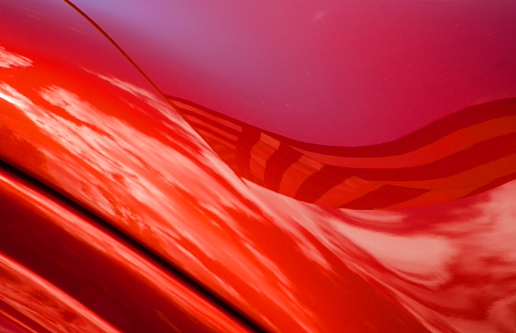 A close-up abstract photograph of a classic red sportscar