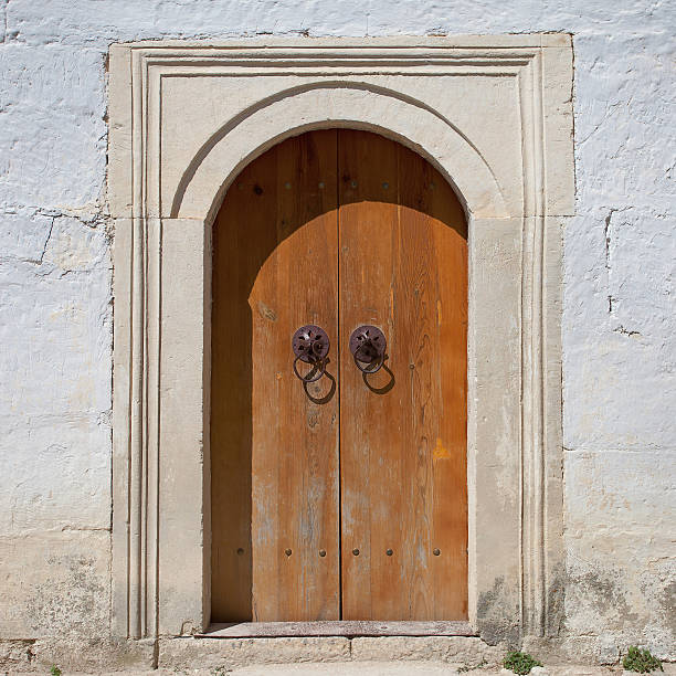 istock ancient stone wall with wooden arch door 535887303