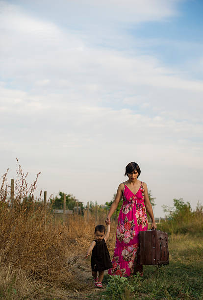 istock Mother and daughter walking with a suitcase 535887375